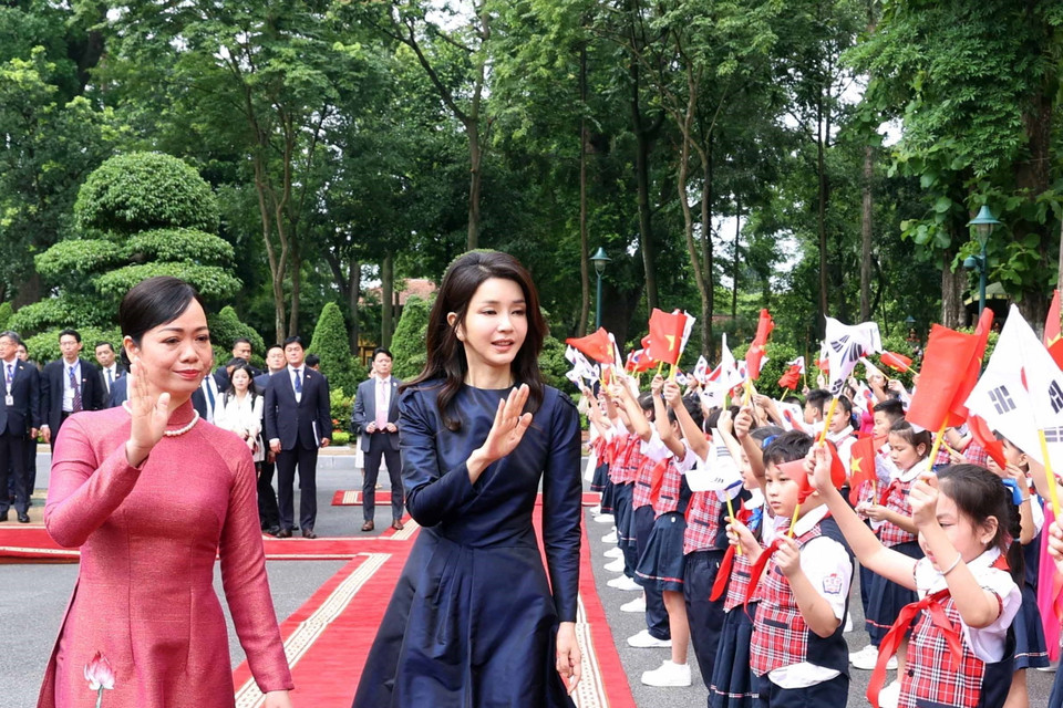 Phu nhân Chủ tịch nước Võ Văn Thưởng và Phu nhân Tổng thống Hàn Quốc Yoon Suk Yeol với thiếu nhi Thủ đô tại lễ đón. (Ảnh: Thống Nhất/TTXVN)