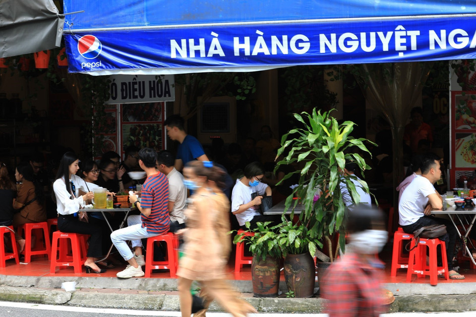 Một số hàng quán ngay trước cửa Phủ Tây Hồ vẫn không thực hiện giãn khoảng cách đúng quy định. (Ảnh: Thành Đạt/TTXVN)