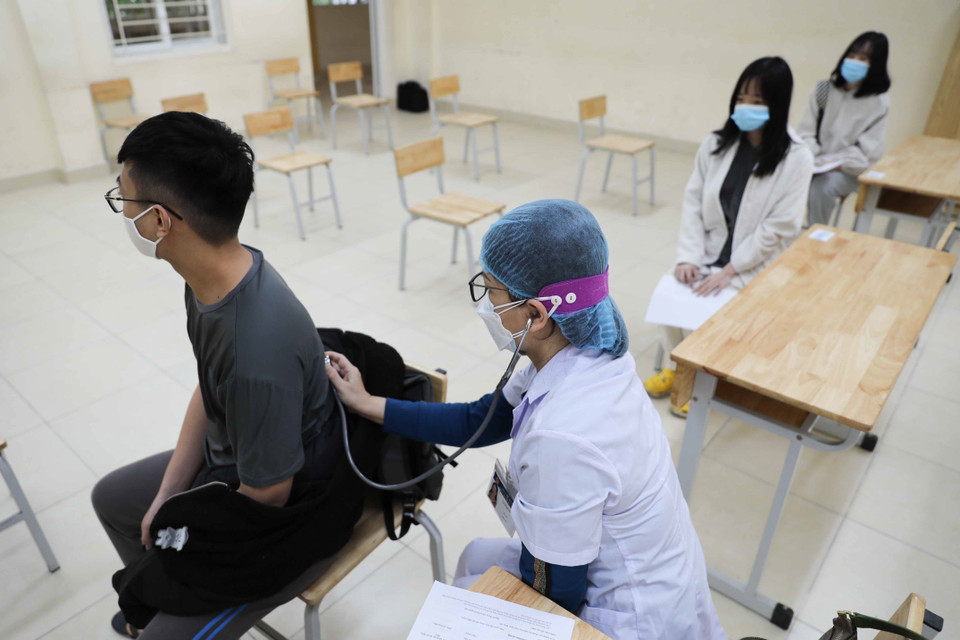 Học sinh trường THPT Trần Nhân Tông, quận Hai Bà Trưng được kiểm tra sức khỏe, khám sàng lọc trước khi tiêm tại trường. (Ảnh: Thanh Tùng/TTXVN)