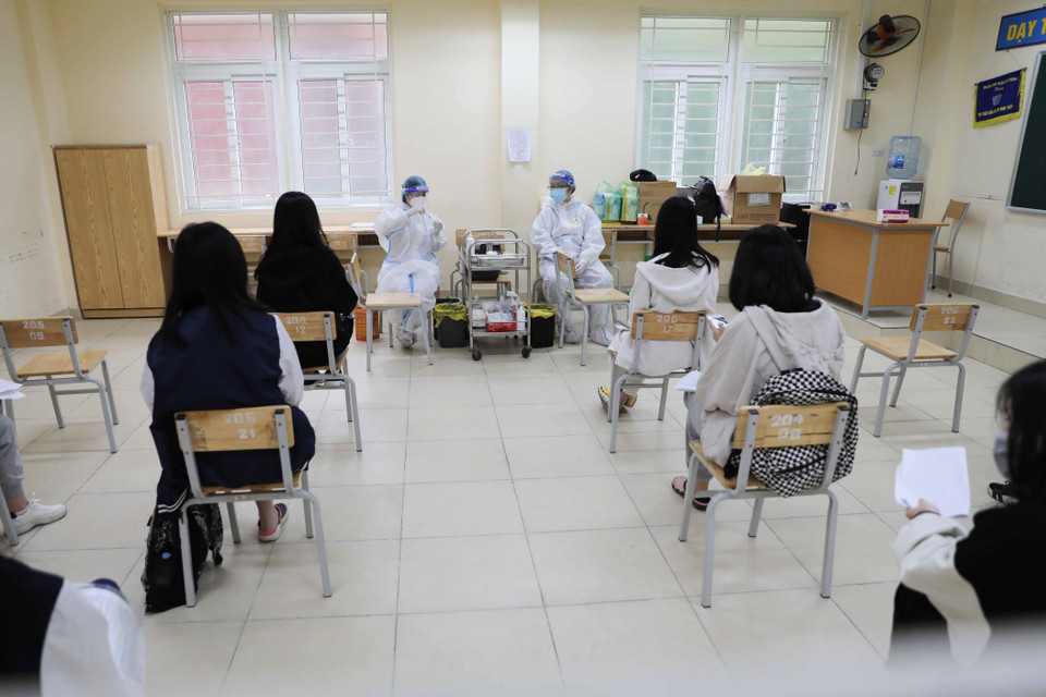 Học sinh trường THPT Trần Nhân Tông, quận Hai Bà Trưng trước giờ tiêm tại trường. (Ảnh: Thanh Tùng/TTXVN)