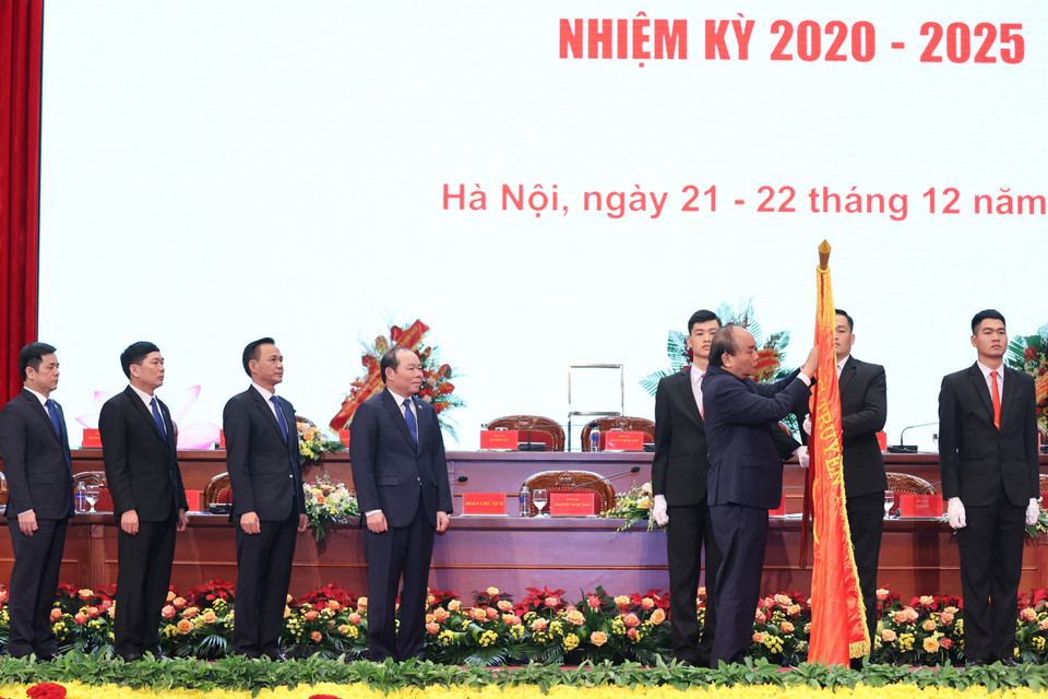 Thủ tướng Nguyễn Xuân Phúc gắn Huân chương Độc lập hạng Nhì lên lá cờ truyền thống của Liên minh Hợp tác xã Việt Nam. (Ảnh: Thống Nhất/TTXVN)