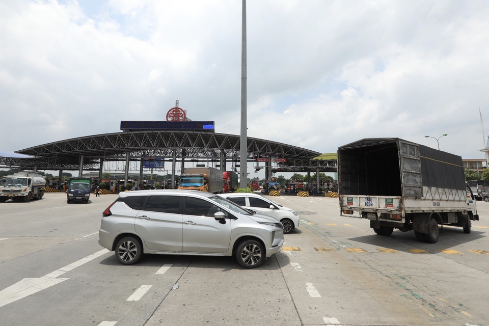 Lực lượng chức năng hướng dẫn các phương tiện quay đầu tại trạm thu phí Pháp Vân-Cầu Giẽ khi thực hiện Chỉ thị 17 của UBND thành phố. (Ảnh: Minh Quyết/TTXVN)