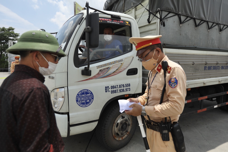 Phương tiện chở hàng thiết yếu sẽ được kiểm tra các điều kiện đảm bảo an toàn phòng, chống dịch COVID-19 khi qua chốt. (Ảnh: Minh Quyết/TTXVN)