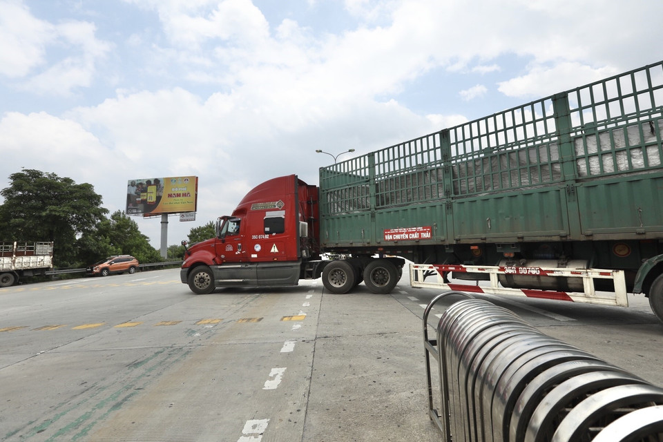 Lực lượng chức năng hướng dẫn các phương tiện quay đầu tại trạm thu phí Pháp Vân-Cầu Giẽ khi thực hiện Chỉ thị 17 của UBND thành phố. (Ảnh: Minh Quyết/TTXVN)