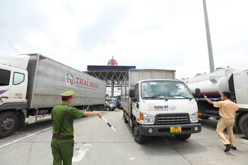 Lực lượng chức năng hướng dẫn các phương tiện quay đầu tại trạm thu phí Pháp Vân-Cầu Giẽ khi thực hiện Chỉ thị 17 của UBND thành phố. (Ảnh: Minh Quyết/TTXVN)