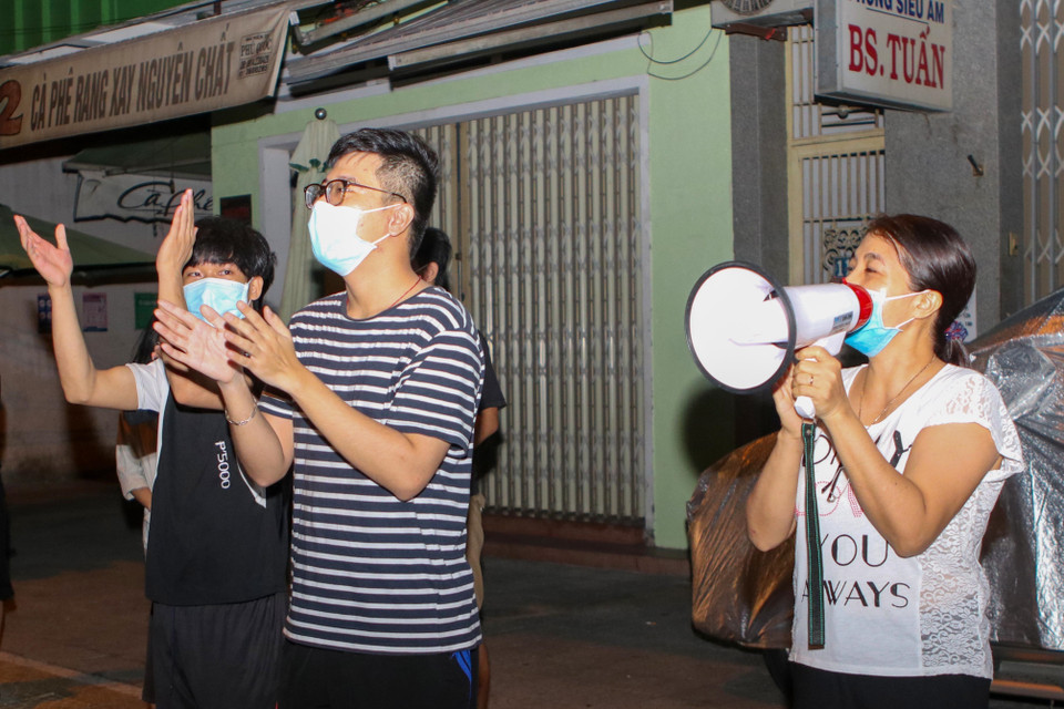 Người dân trên tuyến đường Quang Trung vui mừng khi hoàn thành thời gian cách ly và khu dân cư được gỡ lệnh phong tỏa. (Ảnh: Trần Lê Lâm/TTXVN)