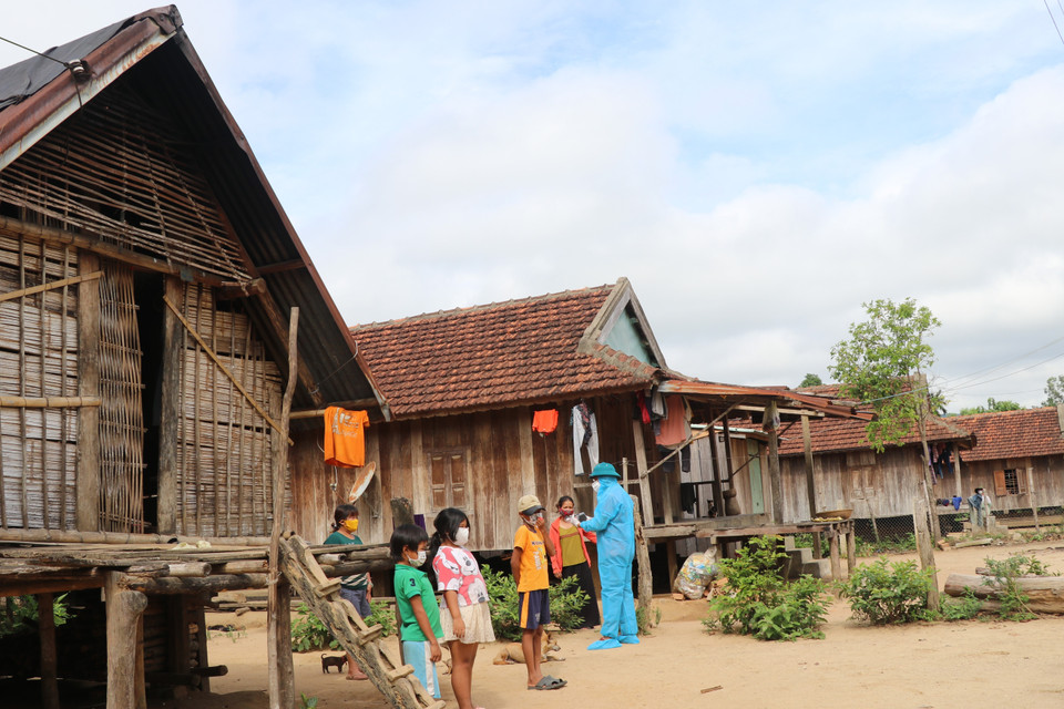 Chủ tịch Ủy ban Nhân dân xã Ea Trol Lê Văn Tấn thăm hỏi, động viên người dân buôn Bầu chấp hành quy định phòng chống dịch. (Ảnh: Phạm Cường/TTXVN)