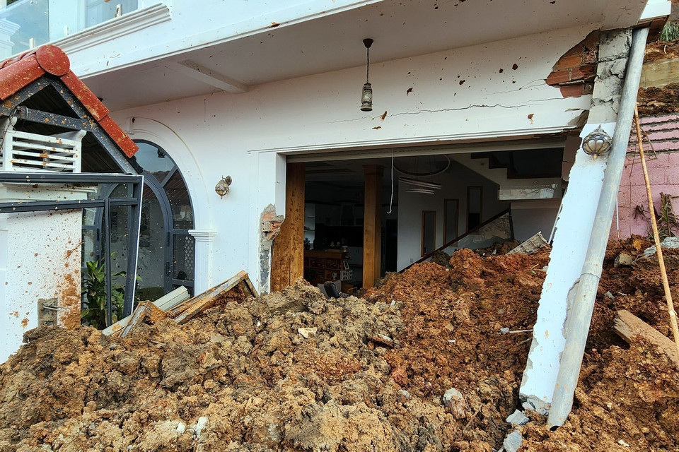 Một căn nhà bị đất đá vùi lấp tầng 1. (Ảnh: Chu Quốc Hùng/TTXVN)