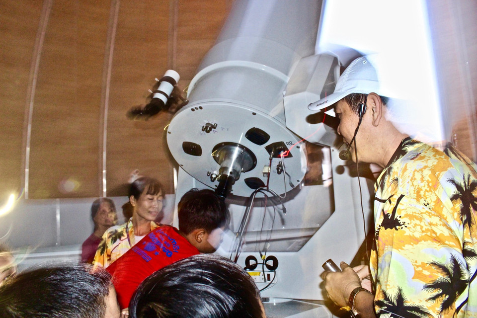 Các bạn nhỏ được trực tiếp ngắm Mặt Trăng thông qua kính thiên văn của Đài thiên văn Nha Trang. (Ảnh: Phan Sáu/TTXVN)