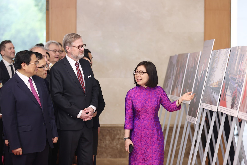 Phó Tổng Giám đốc Thông tấn xã Việt Nam Đoàn Thị Tuyết Nhung giới thiệu trưng bày ảnh với hai Thủ tướng. (Ảnh: Dương Giang/TTXVN)