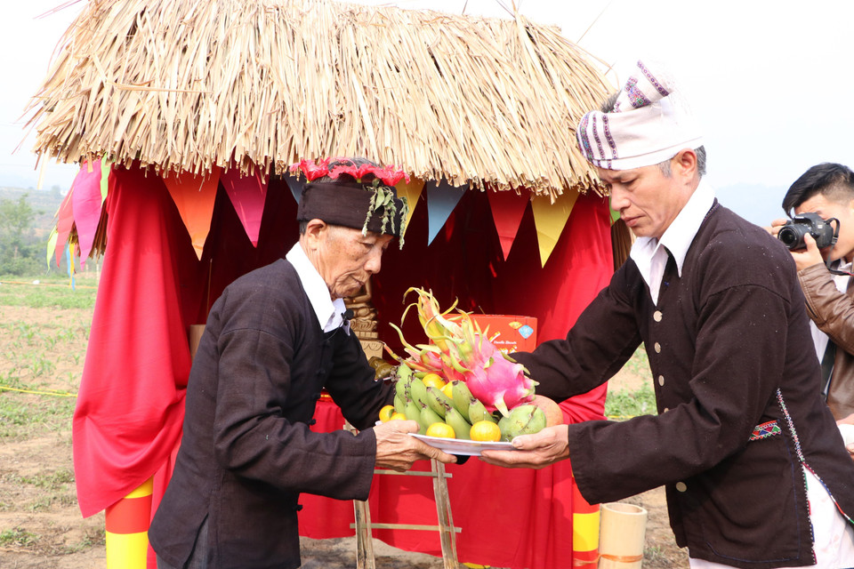 Sau khi dâng hương, thầy cúng sẽ nhận lễ vật từ tay của các già làng để dâng vào chùa. (Ảnh: Đinh Thùy/TTXVN)