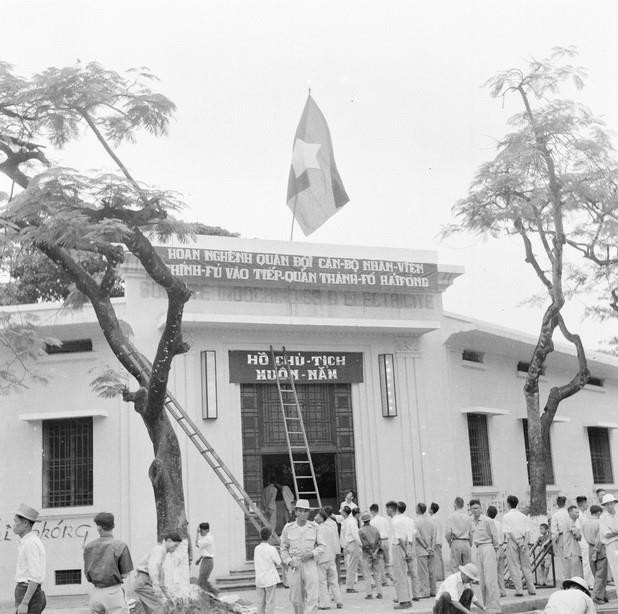 Công nhân nhà máy đèn khu Trung ương treo cờ, làm khẩu hiệu mừng đón bộ đội. (Ảnh: Tư liệu TTXVN)