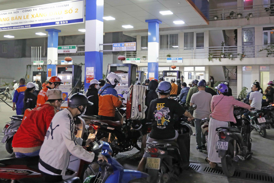 Người dân xếp hàng dài chờ mua xăng, dầu tại cửa hàng kinh doanh xăng, dầu trên phố Lạc Trung, tối 5/11. (Ảnh: Trần Việt/TTXVN)