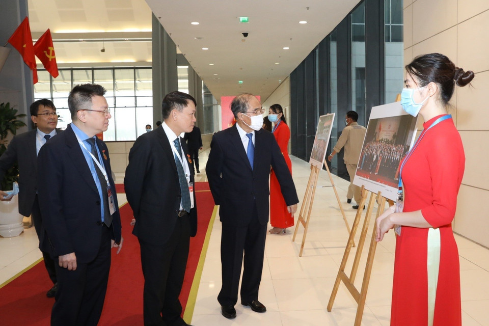 Các vị lãnh đạo Thông tấn xã Việt Nam giới thiệu với nguyên Chủ tịch Quốc hội Nguyễn Sinh Hùng những bức ảnh về phong trào thi đua yêu nước qua các thời kỳ do phóng viên TTXVN thực hiện, trưng bày tại Đại hội. (Ảnh: Văn Điệp/TTXVN)