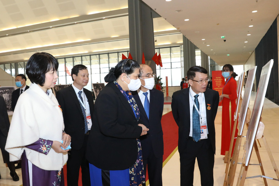 Lãnh đạo Thông tấn xã Việt Nam giới thiệu với Phó Chủ tịch Thường trực Quốc hội Tòng Thị Phóng và nguyên Chủ tịch Quốc hội Nguyễn Sinh Hùng những bức ảnh về phong trào thi đua yêu nước qua các thời kỳ do phóng viên TTXVN thực hiện, trưng bày tại Đại hội. (Ảnh: Văn Điệp/TTXVN)