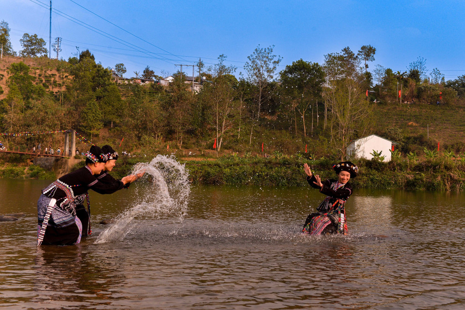 Trai bản trên, gái bản dưới, không phân biệt người già, trẻ nhỏ kéo nhau ra suối thực hiện phong tục té nước. Với quan niệm ướt càng nhiều, may mắn sẽ đến càng nhiều nên ai cũng mong mình được té ướt càng nhiều càng tốt. (Ảnh: Đinh Thùy/TTXVN)
