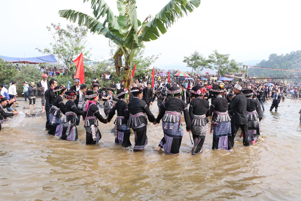Mọi người nắm tay múa xòe quanh cây chuối thể hiện sự đoàn kết tại lễ hội. (Ảnh: Đinh Thùy/TTXVN)