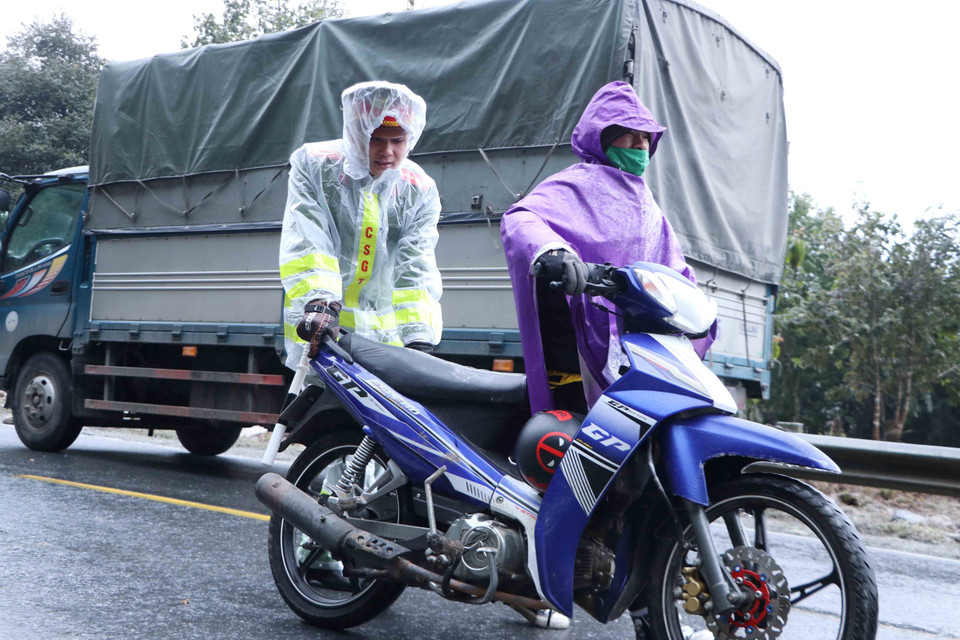 Lực lượng Cảnh sát giao thông giúp người dân di chuyển qua đoạn đường đóng băng. (Ảnh: Nguyễn Oanh/TTXVN)