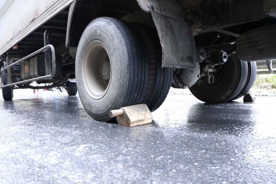 Các chủ xe phải chèn bánh để chống trượt. (Ảnh: Nguyễn Oanh/TTXVN)