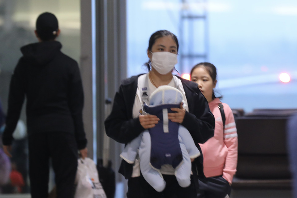 Những công dân Việt Nam sống, làm việc ở Ukraina, về tới sân bay quốc tế Nội Bài. (Ảnh: Lâm Khánh/TTXVN)