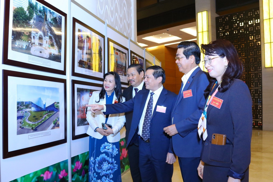 Các đại biểu tham quan triển lãm ảnh được trưng bày tại hội nghị. (Ảnh: Văn Điệp/TTXVN)