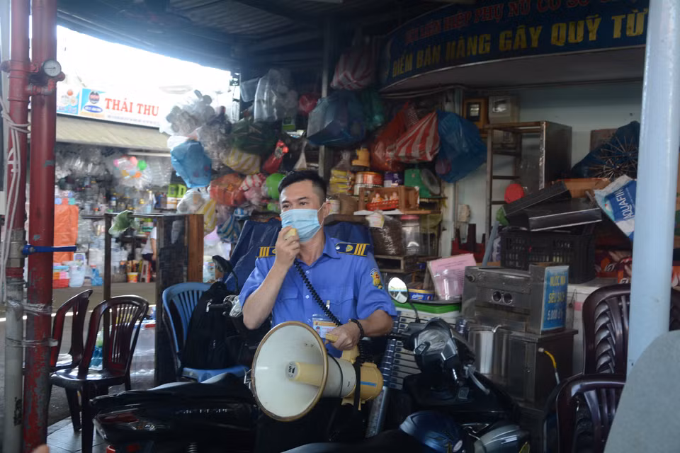 Quản lý Chợ Cồn thường xuyên nhắc nhở người dân thực hiện Thông điệp 5K của Bộ Y tế. (Ảnh: Văn Dũng/TTXVN)
