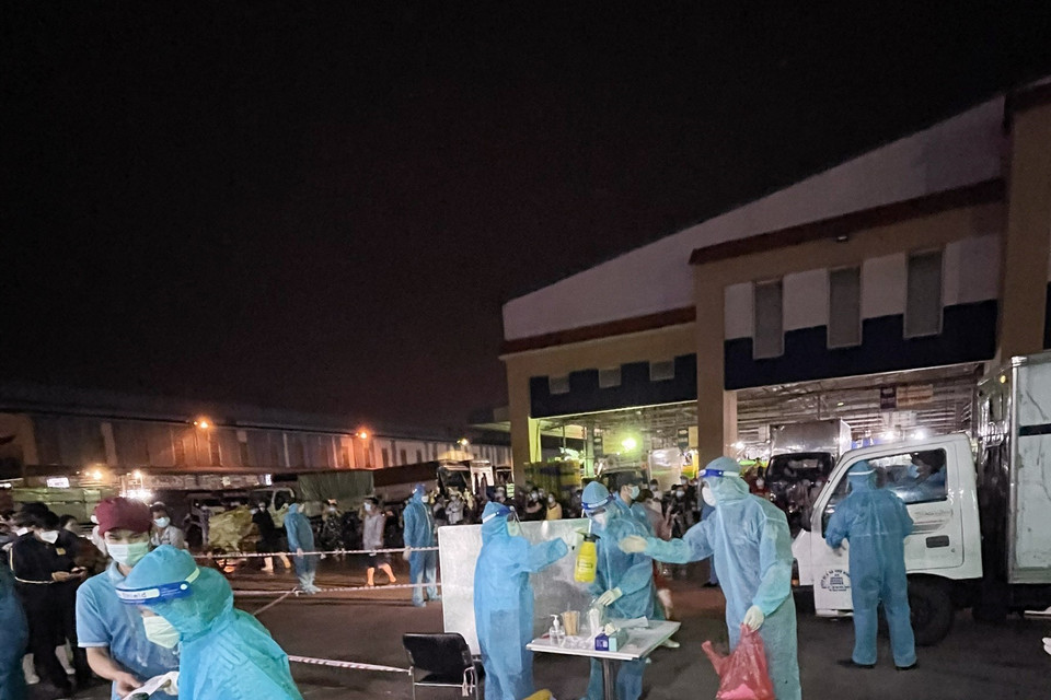 Lực lượng chức năng lấy mẫu tầm soát dịch COVID-19 tại chợ Bình Điền. (Ảnh: TTXVN phát)