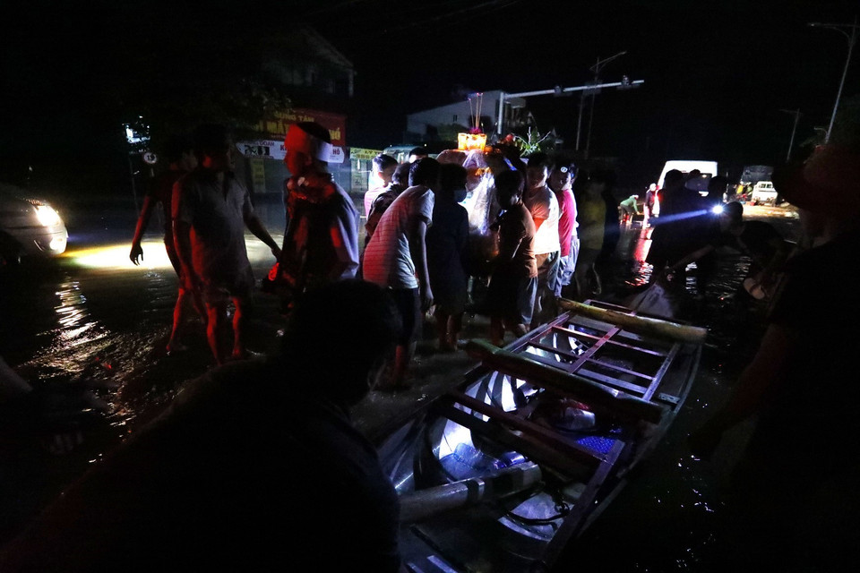 Di chuyển linh cữu lên bè và chuyển tiếp lên khu vực cao. (Ảnh: Thành Đạt/TTXVN)