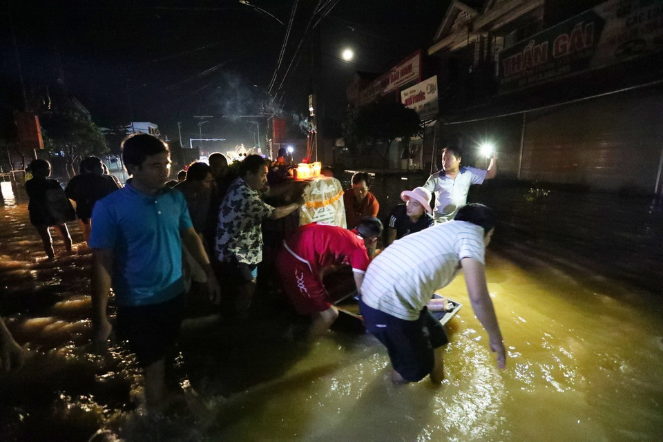 Hình ảnh éo le khi đám tang phải di chuyển trong đêm, xung quanh là nước lũ. (Ảnh: Thành Đạt/TTXVN)