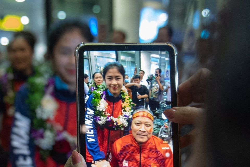 Cầu thủ Thanh Nhã chụp ảnh cùng người hâm mộ tại Sân bay Quốc tế Nội Bài. (Ảnh: Phạm Tuấn Anh/TTXVN)