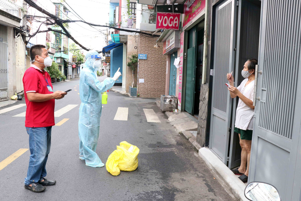 Thiếu úy Vũ Tiến Vũ, Bác sỹ Quân y Học viện Quân y (thứ 2 từ trái sang) thăm khám cho người dân tại đường Đất Thánh, phường 6, quận Tân Bình. (Ảnh: Xuân Khu-TTXVN)