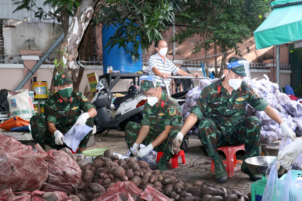 Cán bộ, chiến sỹ Sư đoàn 309 hỗ trợ công tác an sinh xã hội tại phường 6, quận Tân Bình. (Ảnh: Xuân Khu/TTXVN)