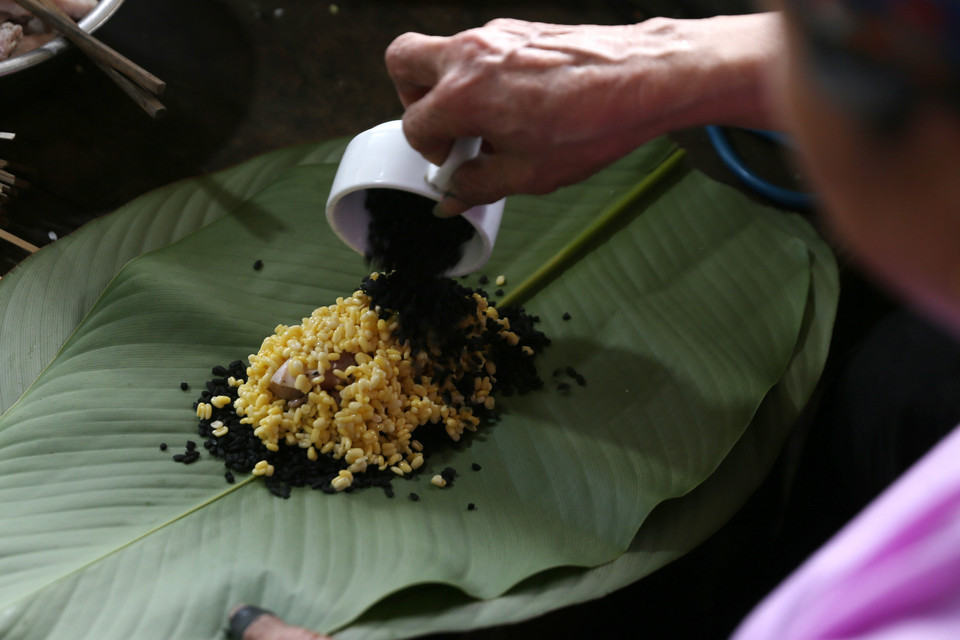 Đồng bào dân tộc người Dáy (Lào Cai) gói bánh chưng đen chuẩn bị đón Tết. (Ảnh: Quốc Khánh/TTXVN)