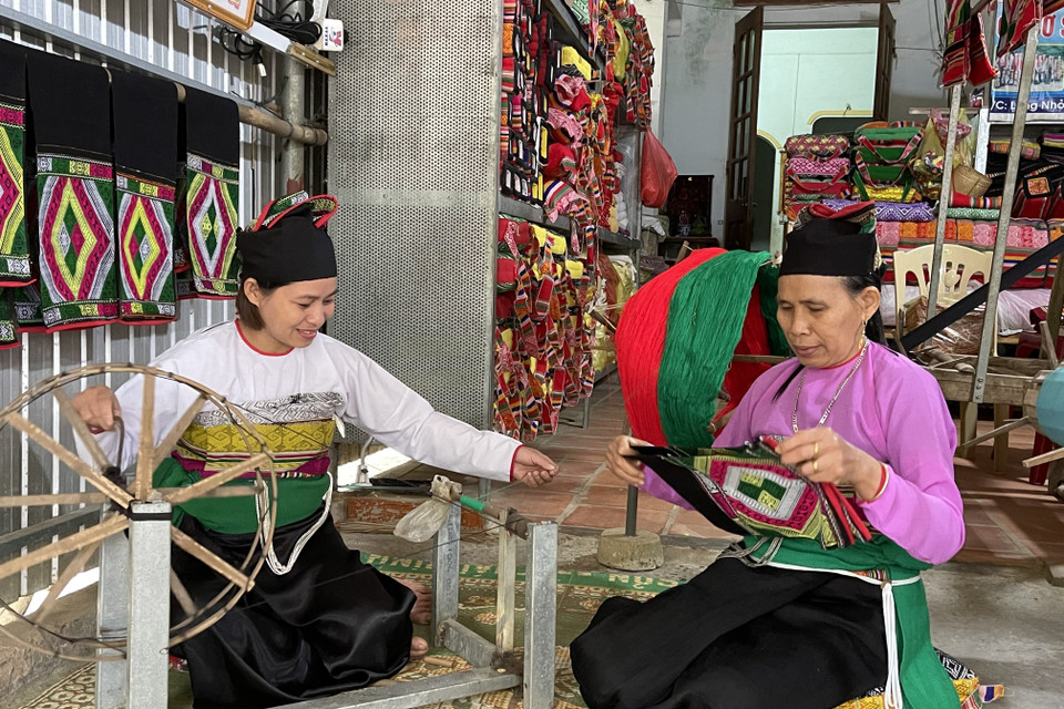 Bằng tâm huyết và đam mê, bà Phạm Thị Bảo (phải) đã truyền lửa cho những người phụ nữ Mường cùng bảo tồn và phát huy nghề dệt thổ cẩm truyền thống của dân tộc mình. (Ảnh: Khiếu Tư/TTXVN)