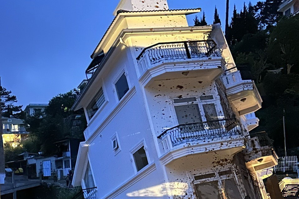 Một căn nhà cao tầng bị đổ nghiêng. (Ảnh: Chu Quốc Hùng/TTXVN)