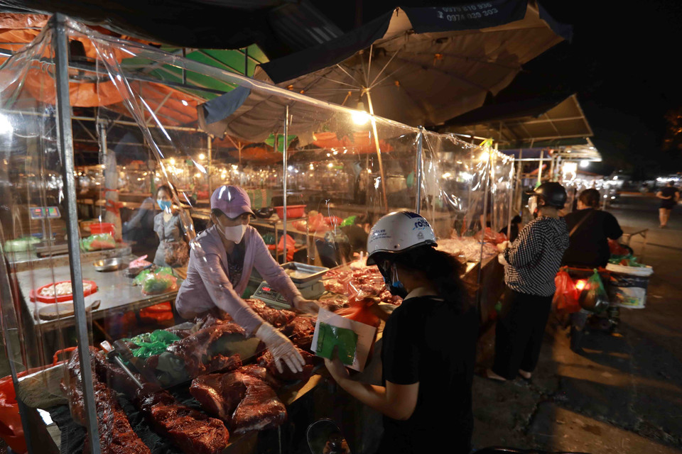 Các hoạt động mua, bán đều phải đảm bảo giữ khoảng cách an toàn và có tấm kính chắn giữa người bán, người mua. (Ảnh: Vũ Sinh/TTXVN)