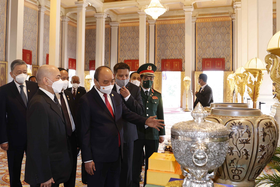 Chủ tịch nước Nguyễn Xuân Phúc và Quốc vương Campuchia Norodom Sihamoni giới thiệu về của quà tặng của 2 nước tại Cung điện Hoàng gia. (Ảnh: Thống Nhất/TTXVN)