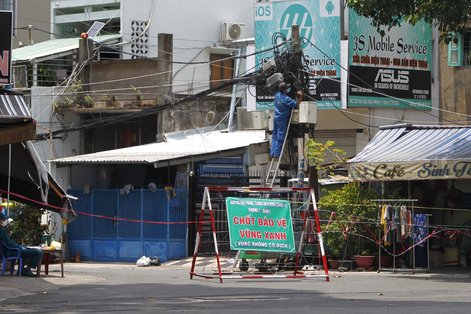 Chính quyền địa phương và nhân dân quận 5 lập rào chắn bảo vệ vùng xanh, không cho người lạ vào khu vực an toàn. (Ảnh: Thanh Vũ/TTXVN)