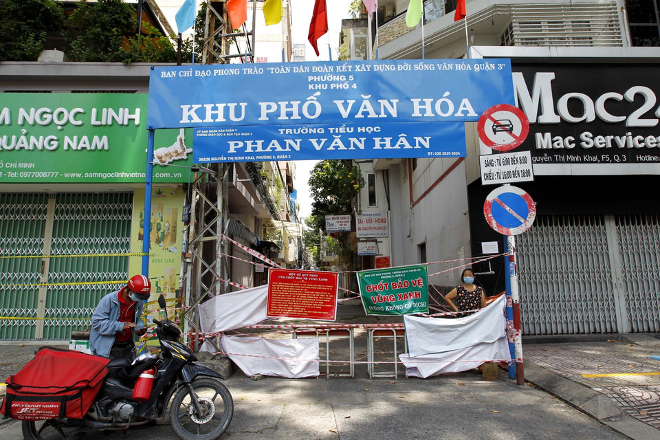 Chính quyền địa phương và nhân dân trong hẻm 382 Nguyễn Thị Minh Khai, quận 3, lập rào chắn bảo vệ vùng xanh, không cho người lạ vào khu vực an toàn. (Ảnh: Thanh Vũ/TTXVN)