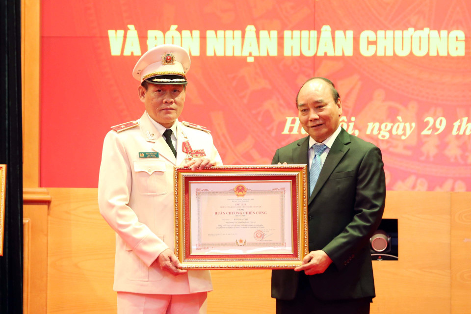 Chủ tịch nước Nguyễn Xuân Phúc trao tặng Huân chương Chiến công hạng Nhì cho Thiếu tướng Đoàn Hùng Sơn, Cục trưởng Cục Ngoại tuyến, Bộ Công an. (Ảnh: Phạm Kiên/TTXVN)