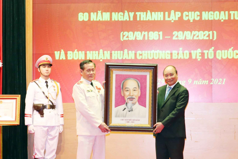 Chủ tịch nước Nguyễn Xuân Phúc trao bức chân dung Chủ tịch Hồ Chí Minh tặng Cục Ngoại tuyến, Bộ Công an. (Ảnh: Phạm Kiên/TTXVN)