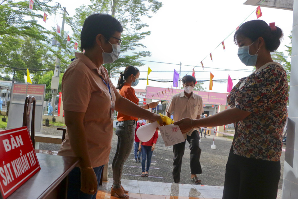 Rửa tay sát khuẩn cử tri tại khu vực bỏ phiếu cố định trước khi bỏ phiếu bầu cử. (Ảnh: Duy Khương/TTXVN)