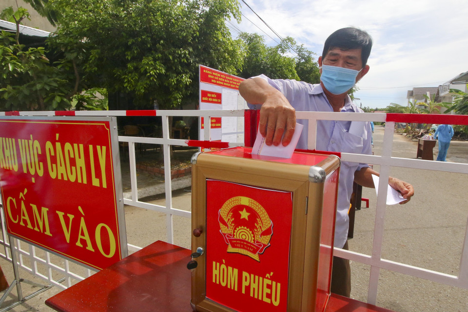 Cử tri vùng cách ly y tế trong khu dân cư (khu vực phong tỏa) tham gia bỏ phiếu bầu cử. (Ảnh: Duy Khương/TTXVN)