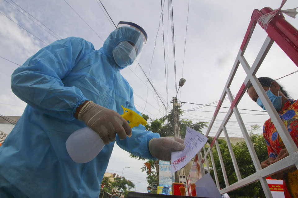 Sát khuẩn phiếu cử tri vùng cách ly y tế trong khu dân cư (khu vực phong tỏa) sau khi bỏ phiếu bầu cử xong. (Ảnh: Duy Khương/TTXVN)