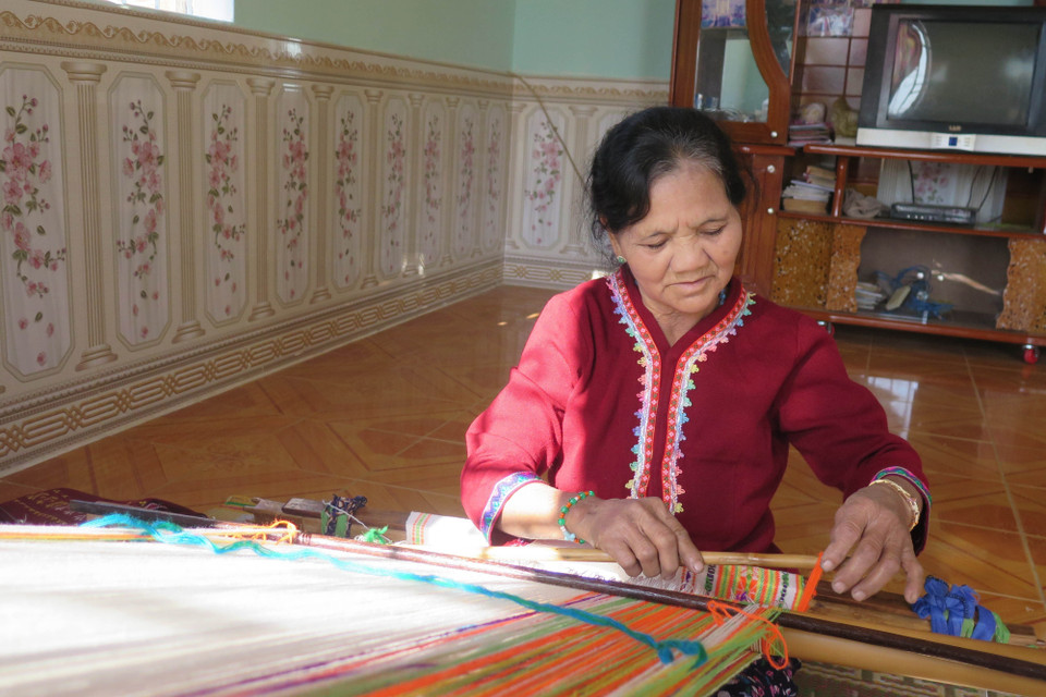 Nghệ nhân Y Thút (sinh năm 1954, tổ trưởng tổ dệt thổ cẩm thôn Đăk Triêng Kơ Tu) bên khung dệt. (Ảnh: Dư Toán/TTXVN)