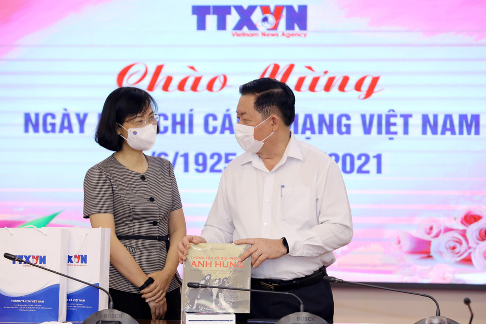 Phó Tổng giám đốc TTXVN Vũ Việt Trang tặng sách của TTXVN cho Trưởng Ban Tuyên giáo Trung ương Nguyễn Trọng Nghĩa. (Ảnh: Nguyễn Điệp/TTXVN)