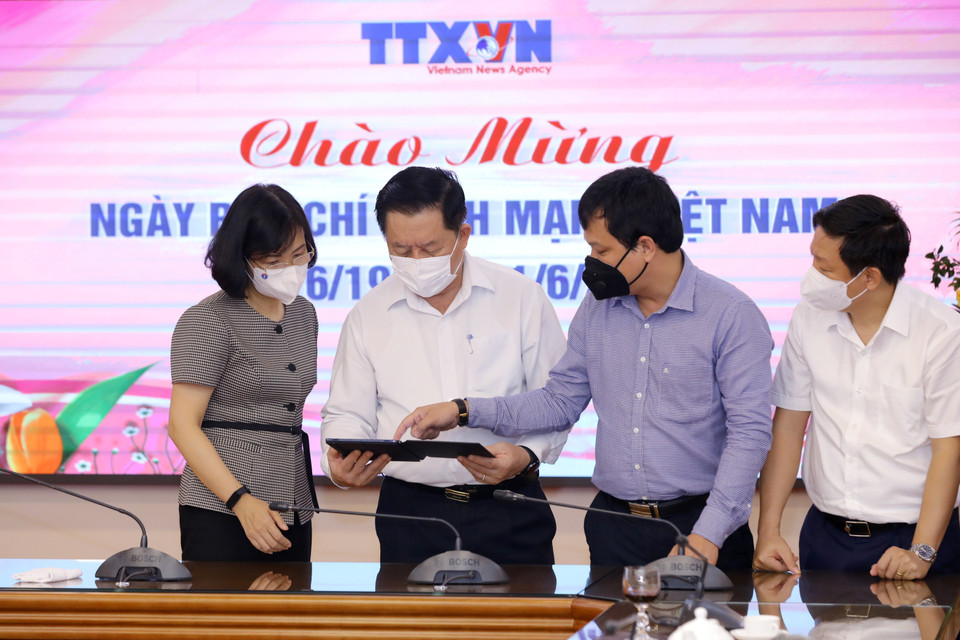 Phó Tổng Giám đốc TTXVN Vũ Việt Trang giới thiệu các ấn phẩm điện tử của TTXVN với Trưởng Ban Tuyên giáo Trung ương Nguyễn Trọng Nghĩa. (Ảnh: Nguyễn Điệp/TTXVN)