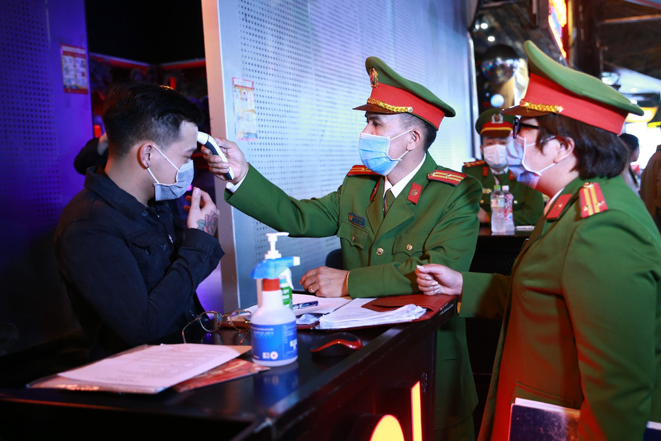 Lực lượng Công an quận Hoàn Kiếm kiểm tra thiết bị đo thân nhiệt tại vũ trường The Bunker, nơi tập trung đông người tại phố Mã Mây, quận Hoàn Kiếm. (Ảnh: Doãn Tấn/TTXVN)