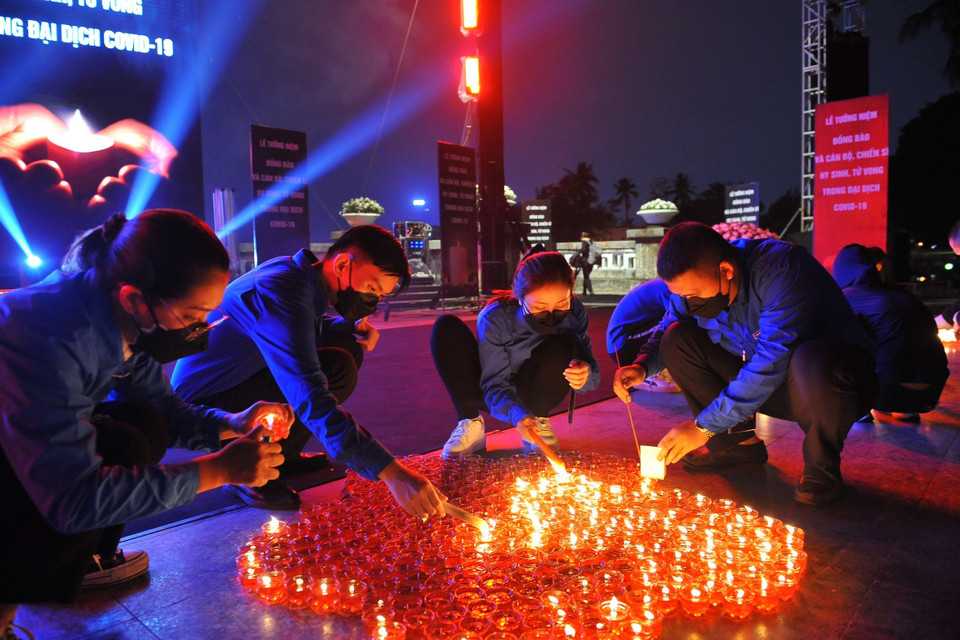 Tại Công viên Thống Nhất (Hà Nội), các đại biểu và nhân dân thắp nến tưởng niệm đồng bào và cán bộ, chiến sỹ hy sinh, tử vong trong đại dịch COVID-19. (Ảnh: Minh Đức/TTXVN)