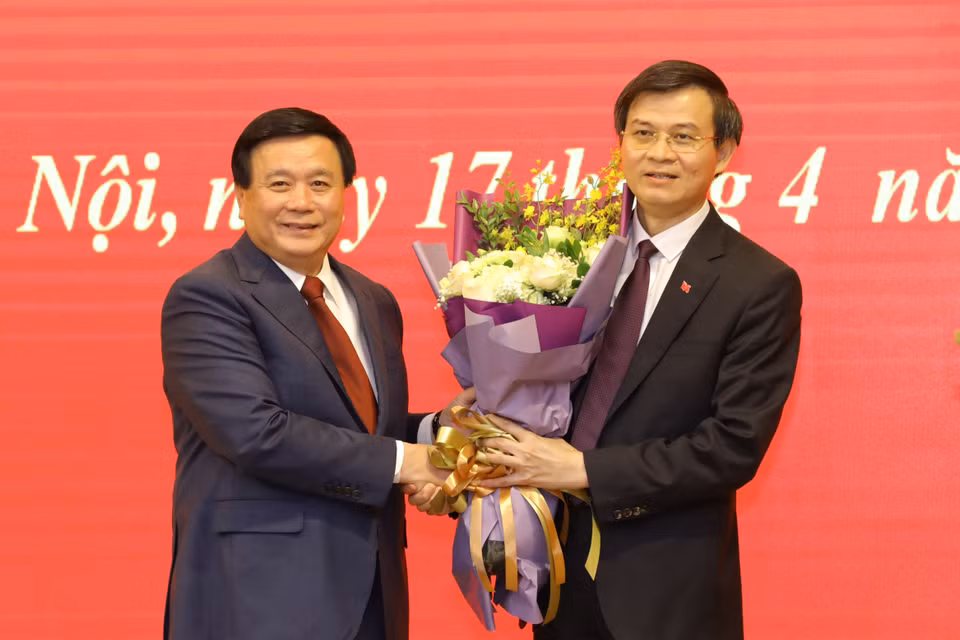 Ủy viên Bộ Chính, Chủ tịch Hội đồng Lý luận Trung ương Nguyễn Xuân Thắng tặng hoa Ủy viên Trung ương Đảng, Tổng biên tập Tạp chí Cộng sản Đoàn Minh Huấn. (Ảnh: Văn Điệp/TTXVN) 